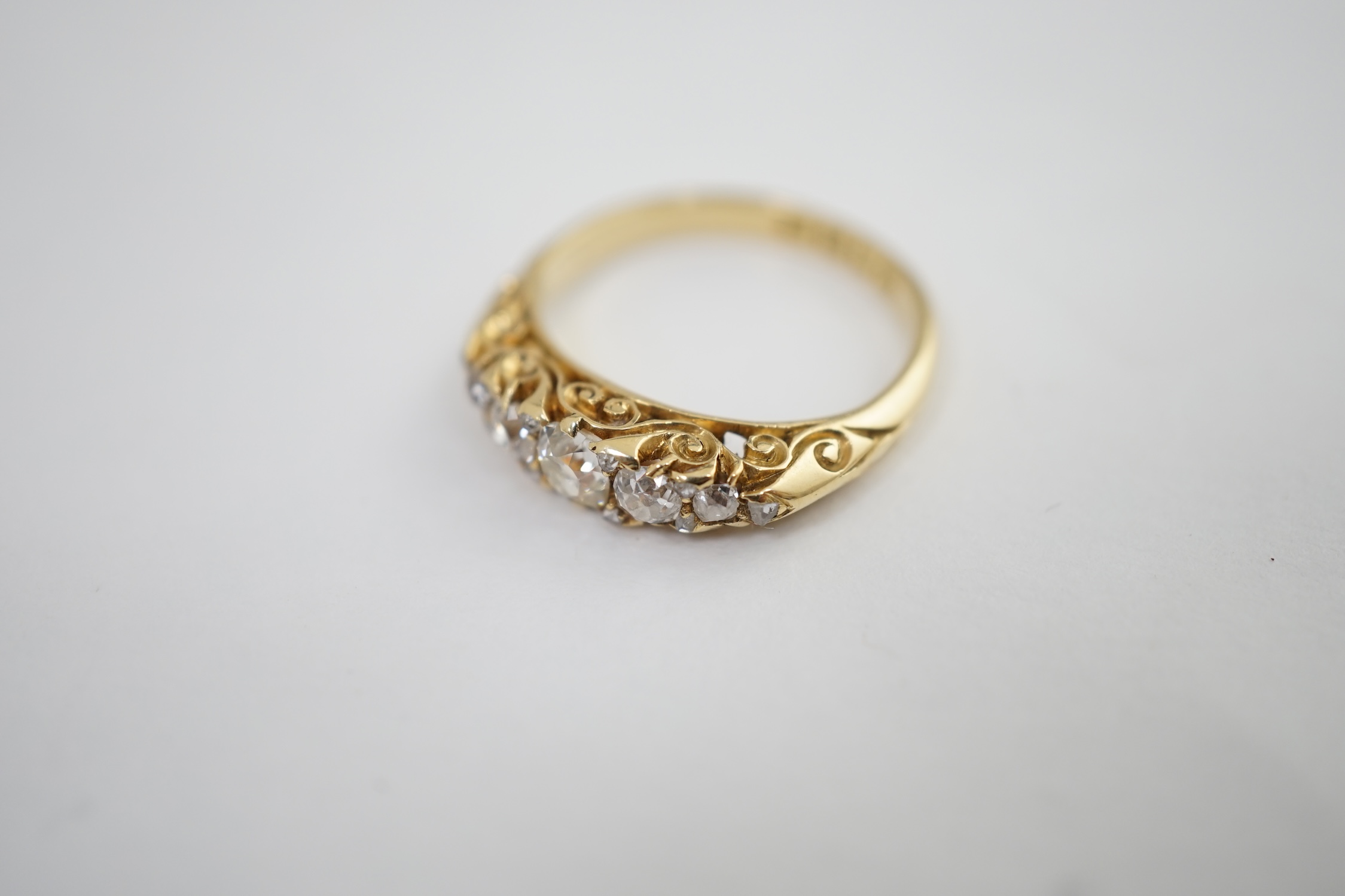 A late Victorian 18ct gold and graduated seven stone diamond set half hoop ring